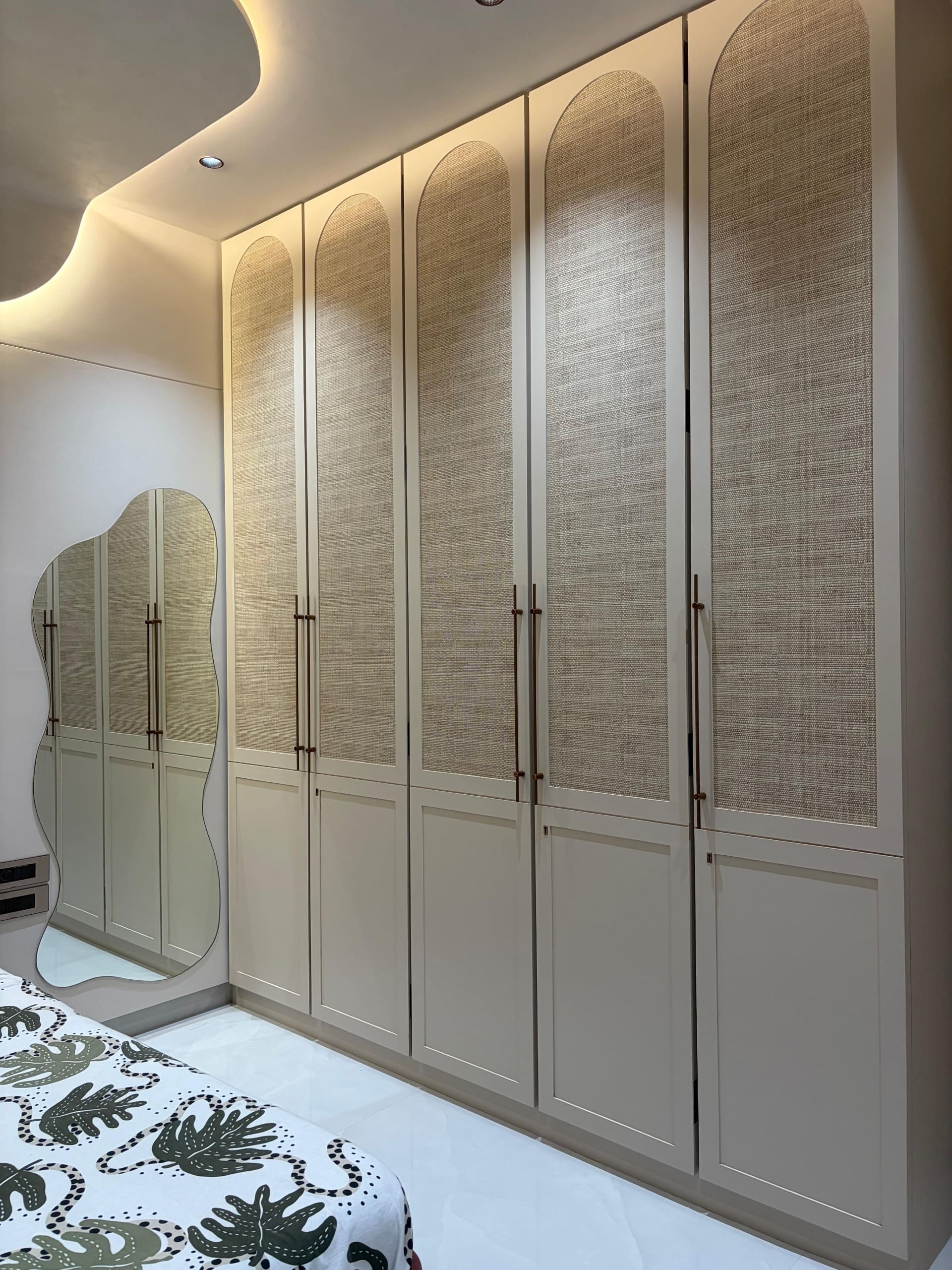 Cane-fronted wardrobe arches and wavy mirror